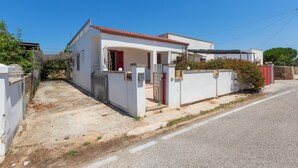 Ein eingeschossiges Haus mit rotem Ziegeldach, einem verschlossenen Eingang und einer kleinen Veranda.