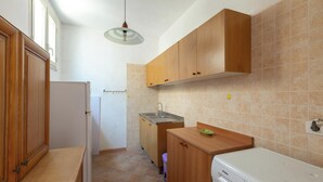 Eine kleine Küche mit Holzschränken, einer integrierten Spüle und einem Geschirrspüler.
