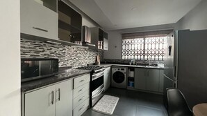 Eine moderne Küche mit Mikrowelle, Backofen und Waschmaschine.