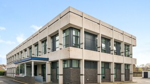 A modern building with a flat roof, large windows, and a blue awning. - 2-Bed Staines Stay | Parking | Heathrow & London Access (Staines-upon-Thames)