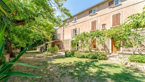 Un bâtiment doté d’un jardin, d’un sentier et d’un arbre.