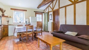 Eine gemütliche Küche mit Esstisch und Stühlen, einer Couch und einem Fliesenboden.