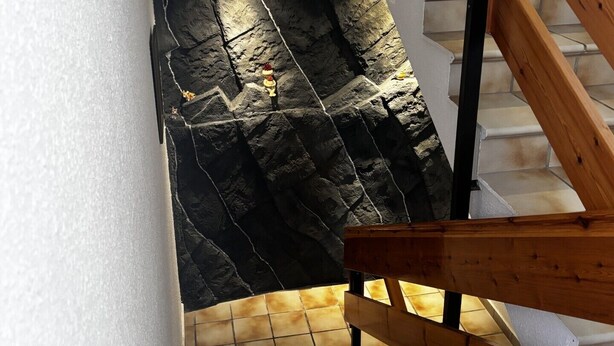 A staircase with wooden handrails and a stone wall at the bottom. - Hostal Kimboa (Ansó)