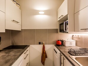 A modern kitchen with white cabinets, a microwave, a kettle, and a bread maker on the counter. - 2-room apartment near slopes - 5 people (La Plagne Montchavin Les Coches)