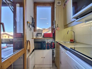 A compact kitchen with a window, a microwave, a coffee maker, and a sink. - Central studio with balcony in Belle Plagne, 4 pers (Belle Plagne)