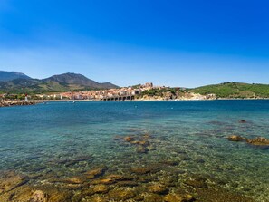 A coastal town with clear waters, rocky shore, and buildings on a hillside. - Studio with garden near the beach - Banyuls-sur-Mer (Banyuls-sur-Mer)