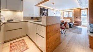 Eine moderne Küche mit integriertem Essbereich, Holzakzenten und Blick ins Freie.