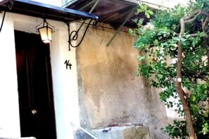 Ein Gebäudeeingang mit einer dunklen Tür, einer weißen Wand und der Zahl 14 an der Wand.