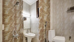 Un baño con lavamanos pedestal, inodoro y ducha.