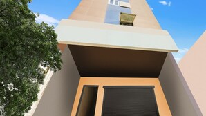 Un edificio moderno con techo plano, un ventanal grande y una puerta.