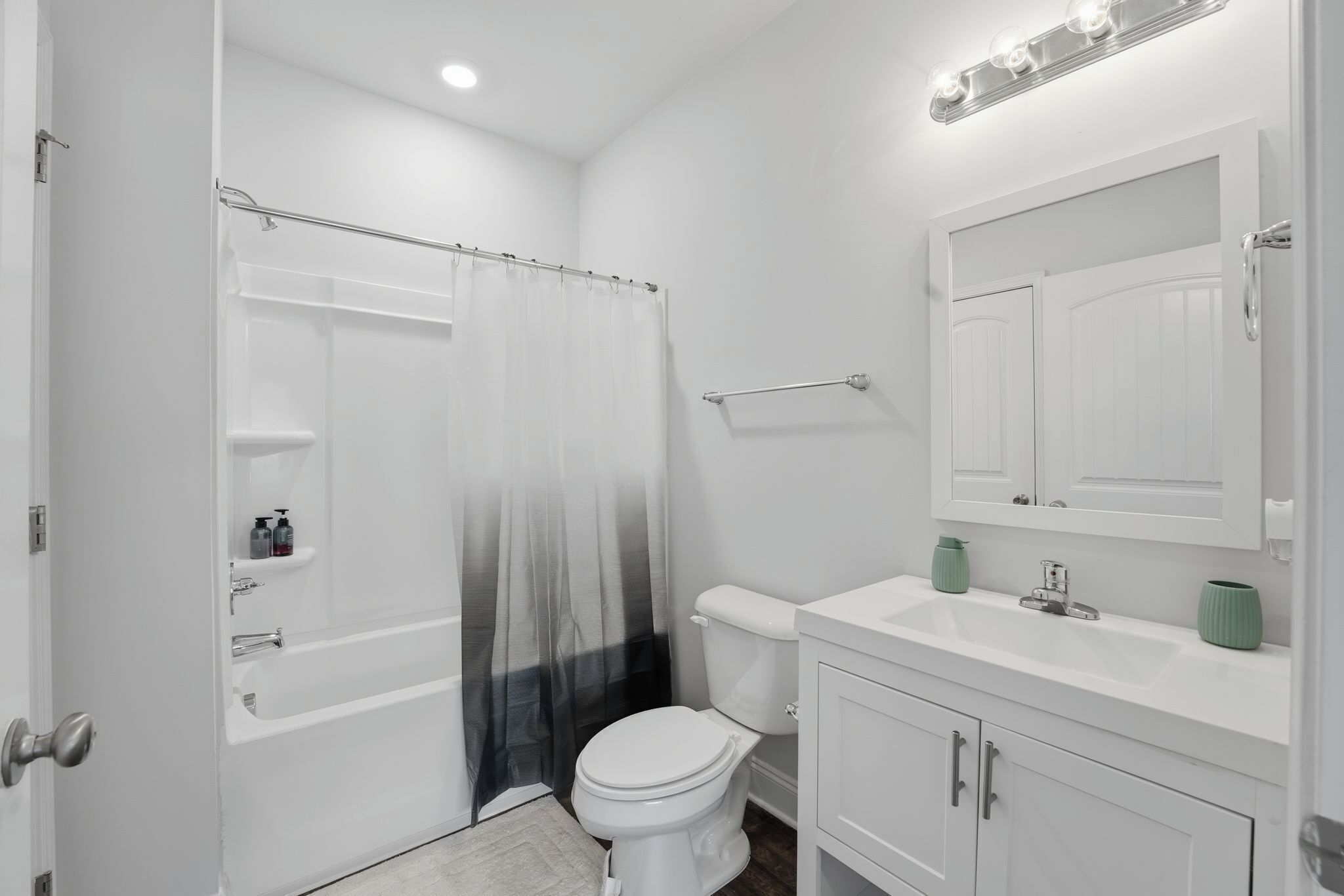 A modern bathroom with a shower, toilet, sink, and vanity.