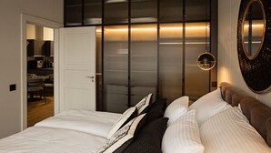 A bedroom with a bed, a bedside table, a mirror, and a wardrobe with a sliding door. - Apartment Husarski comfort 2-bedroom apartment - swimming pool and saunas (Poznań)