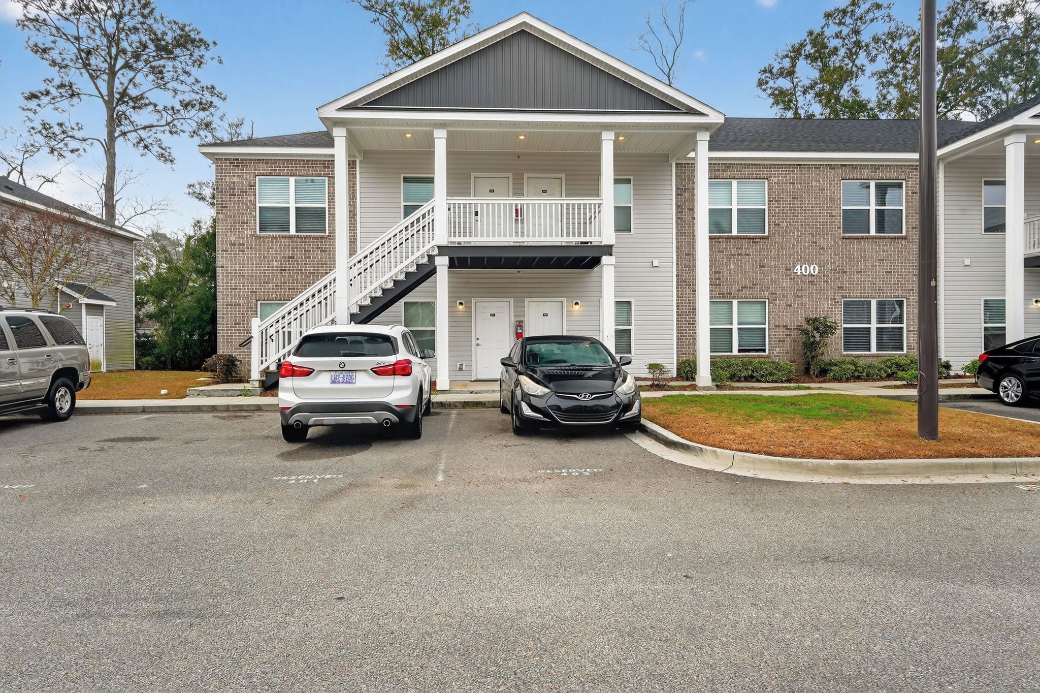 A two-story building with a covered entrance and a staircase leading to the second floor.