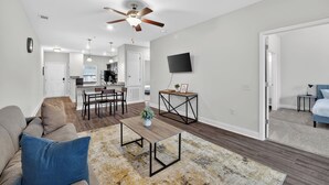 Un salon moderne avec un canapé, une table basse et un coin repas.