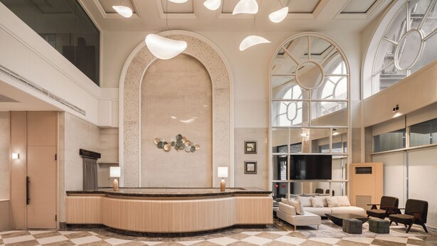A lobby with a checkered floor, a reception desk, seating area, and large windows. - MUMU JIAO-XI (Jiaoxi)