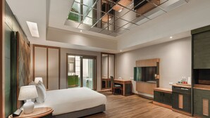 A modern hotel room with a large bed, a desk, a TV, and a seating area. - MUMU JIAO-XI (Jiaoxi)
