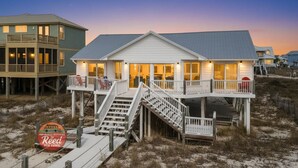 Una casa frente al mar con balcón, escaleras y terraza.