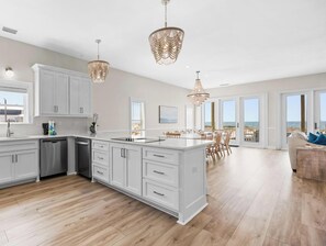 A spacious kitchen with white cabinetry, a central island, and pendant lighting. - East Side Gorgeous 6 Br 4.5 Ba Beach Front Duplex - Newly Renovated! (Gulf Shores)