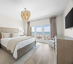 A bedroom with a bed, a desk, a TV, and a balcony with a view of the sea. - West Side Gorgeous 6 Br 4.5 Ba Beach Front Duplex - Newly Renovated! (Gulf Shores)