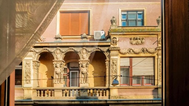 A building facade with ornate architectural details, including columns and statues. - König Hotel (Pécs)