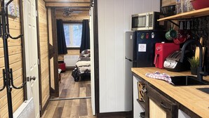 Eine kleine Küche mit Holzboden, einer Mikrowelle, einem Toaster und einem Spülbecken.