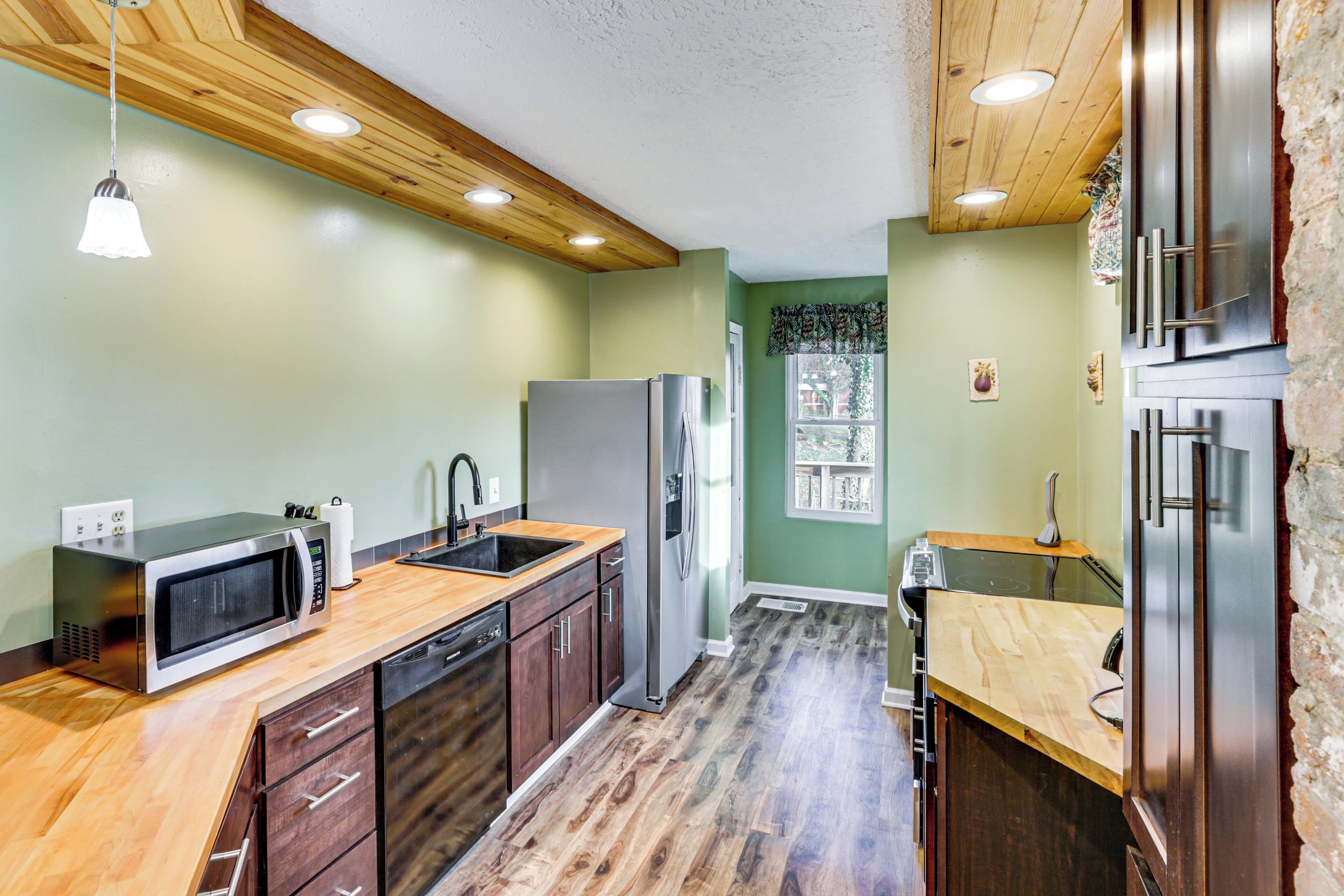 A modern kitchen with wooden cabinets, stainless steel appliances, and a wooden floor.