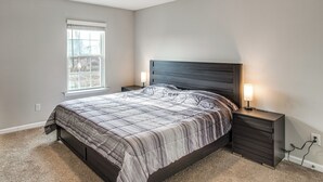 A bedroom with a bed, a nightstand, a lamp, a window, and a wall socket. - 5 Mi to Sesquicentennial State Park: Quiet Home (Columbia)