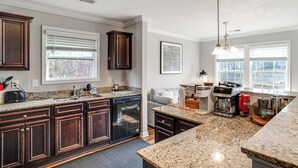 A kitchen with dark wooden cabinets, granite countertops, a dishwasher, and a coffee maker. - 5 Mi to Sesquicentennial State Park: Quiet Home (Columbia)