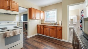 A kitchen with wooden cabinets, a stove, and a sink. - 1 Mi to Dtwn, Chase Field! Getaway Near Light Rail (Phoenix)