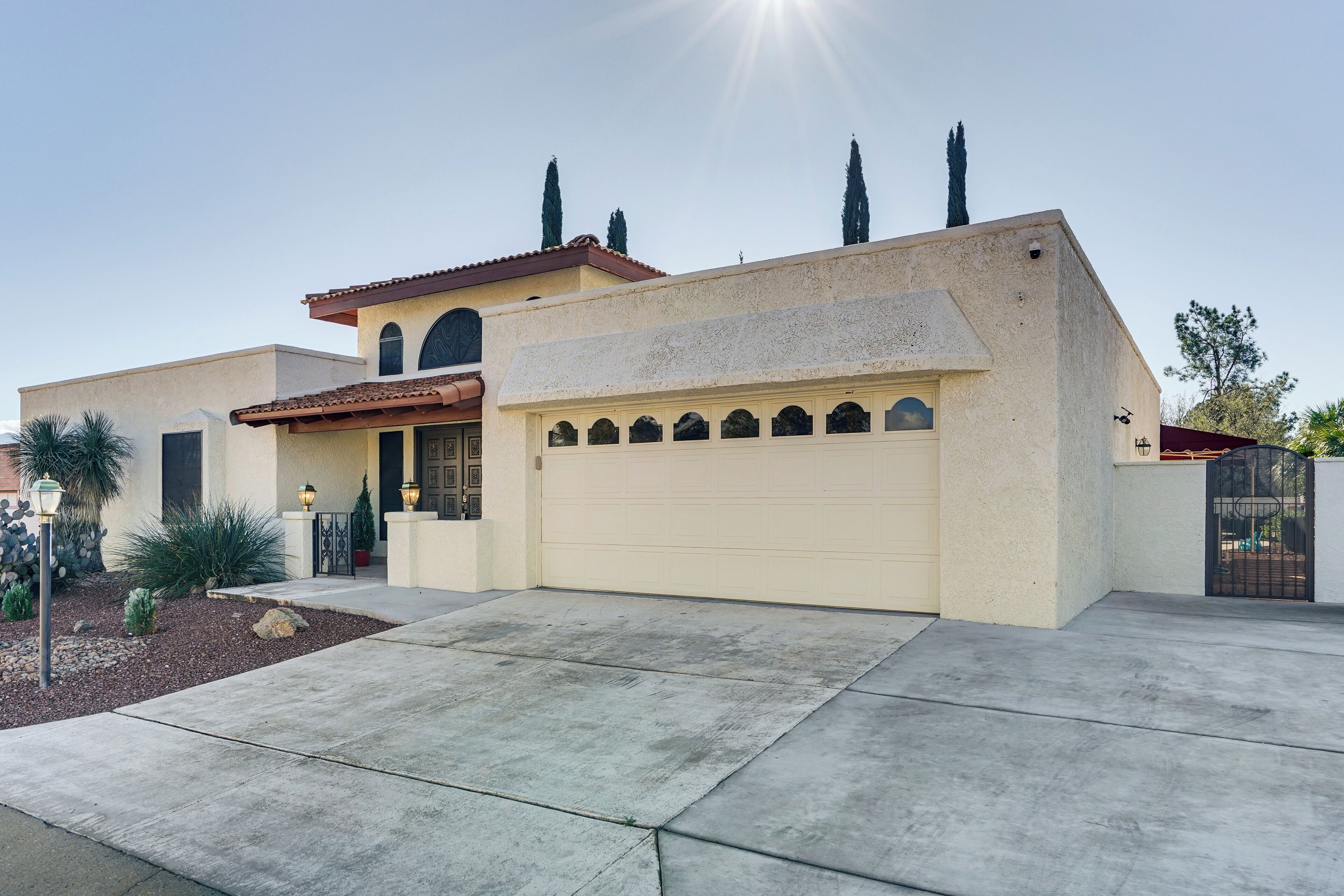 A modern house with a large garage, a well-maintained lawn, and a clear sky.