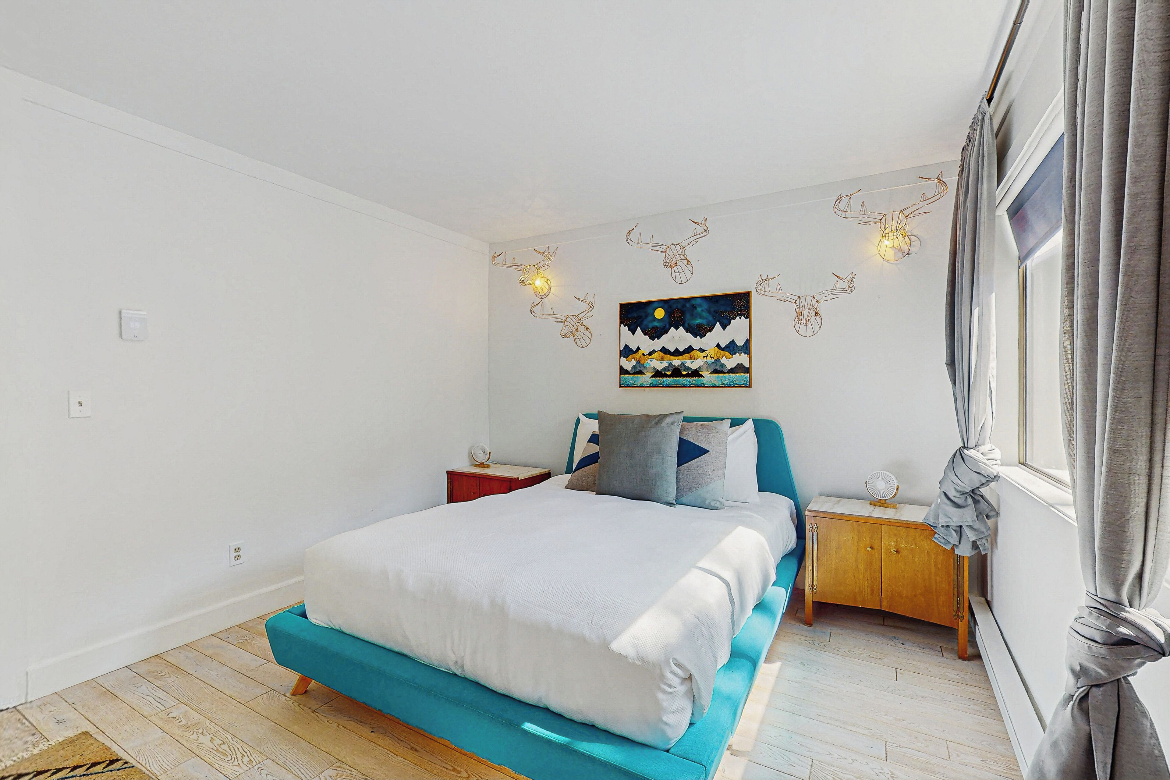 Quarto com cama, mesa de cabeceira, armário de madeira e um quadro na parede.