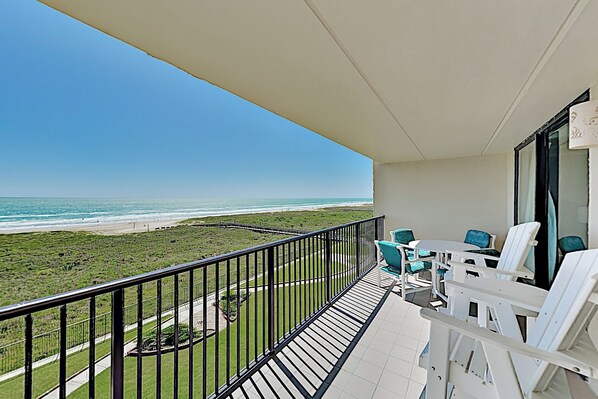 Un balcon avec vue sur la plage et l’océan.