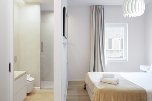 A modern hotel room with a bed, a shower, a toilet, and a window with curtains. - Marques DE Pombal Grand Prestige by Homing (Lisbon)