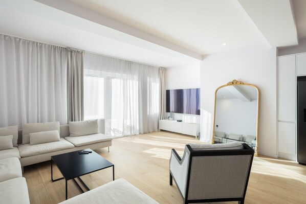 Ein modernes Wohnzimmer mit einer Couch, einem Couchtisch und einem großen Spiegel.