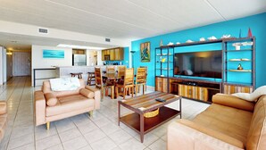 Amplia sala de estar con un sofá, una mesita de centro y un mueble para televisión.