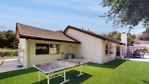 Ein Haus mit einem Pingpongtisch im Garten.