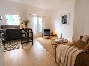 A modern living space with a kitchen, dining area, and seating area. - L'appartement Haudriettes (Paris03)