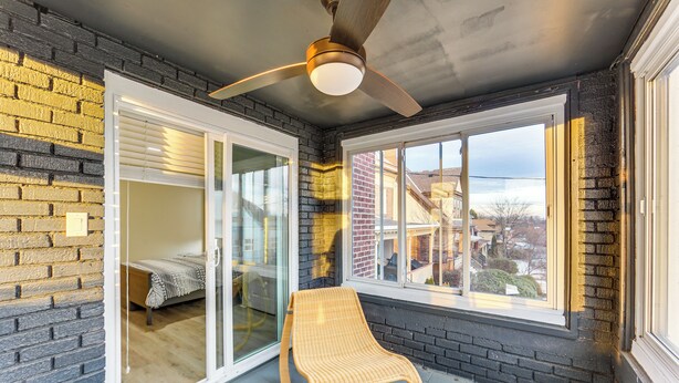 A room with a glass door leading to a balcony, a ceiling fan, and a view of the neighborhood. - 4 Mi to Market Square: Bright Apt w/ Balconies (Pittsburgh)