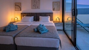 Habitación doble con dos camas, un ventanal grande y obras de arte en las paredes.