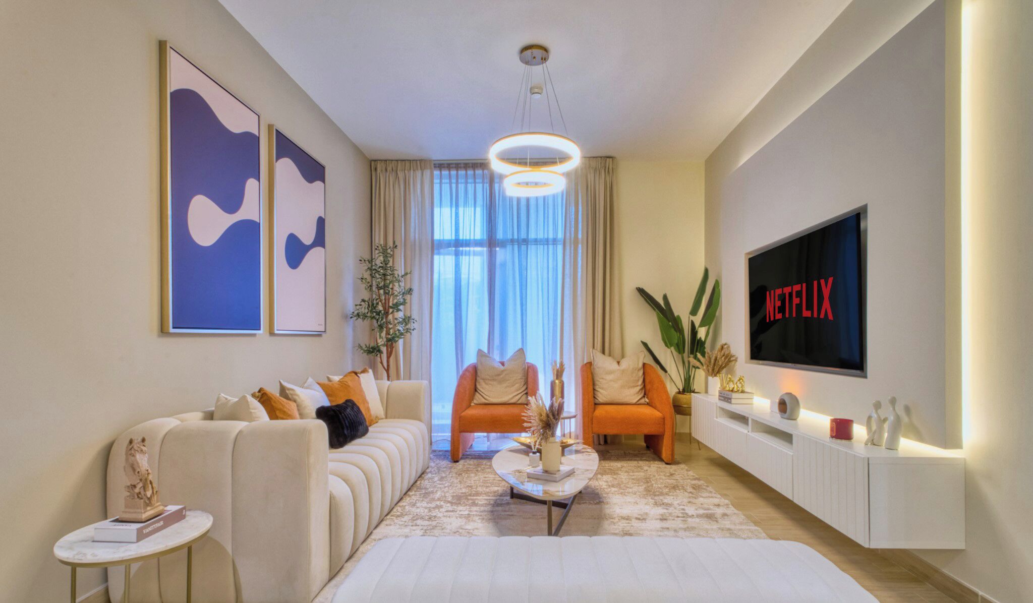 Ett modernt vardagsrum med en soffgrupp, ett soffbord, en tv och ett stort fönster med gardiner.
