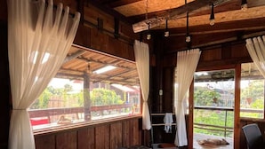 A wooden cabin room with a large bed, curtains, and a view of the outdoors. - Room-boutique Cabin · Peaceful Mountain (Chiang Dao)