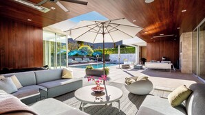 A modern outdoor living area with a pool, seating, and a ceiling fan. - Above Palm Springs Sanctuary | Mountain Views | Pool & Spa | Old Las Palmas (Palm Springs)