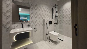 A modern bathroom with a vanity, a shower, and a large mirror. - Palm Boutique Alsalamah  (Jeddah)