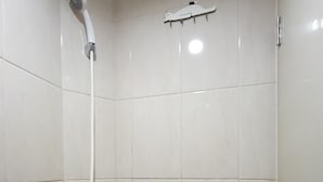 A shower with a handheld showerhead and a wall-mounted faucet. - Apartemen Osaka Riverview by Linkara (Teluknaga)