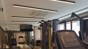 Une salle de sport moderne équipée de tapis de course, d’appareils de musculation et de ballons d’exercice.