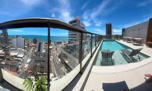 Une piscine sur le toit offrant une vue dégagée sur la ville et l’océan.