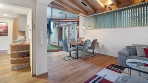 Un interior moderno con comedor, sofá y vista a través de un ventanal.