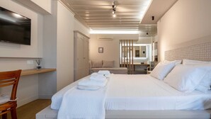 Une chambre d’hôtel moderne, dotée d’un grand lit, d’un bureau et d’une télévision.