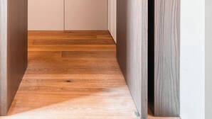 A narrow hallway with wooden flooring and a door at the end. - w Modern 1BR w Balcony in Porta Venezia (Milan)