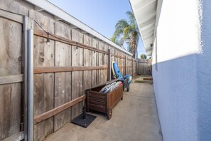 A wooden fence with a wooden cart and a blue chair leaning against it. - Carlsbad Bungalow Large Backyard (Carlsbad)